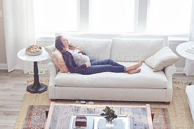 Buy stock photo Full length shot of an attractive young pregnant woman relaxing on the sofa at home
