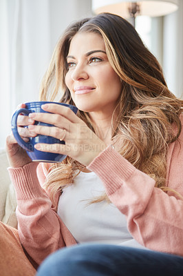 Buy stock photo Shot of a beautiful young woman having coffee while relaxing at home