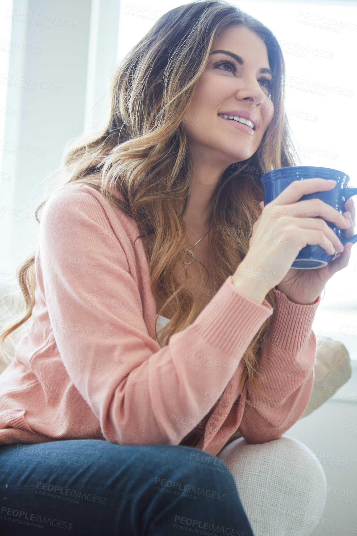 Buy stock photo Shot of a beautiful young woman having coffee while relaxing at home