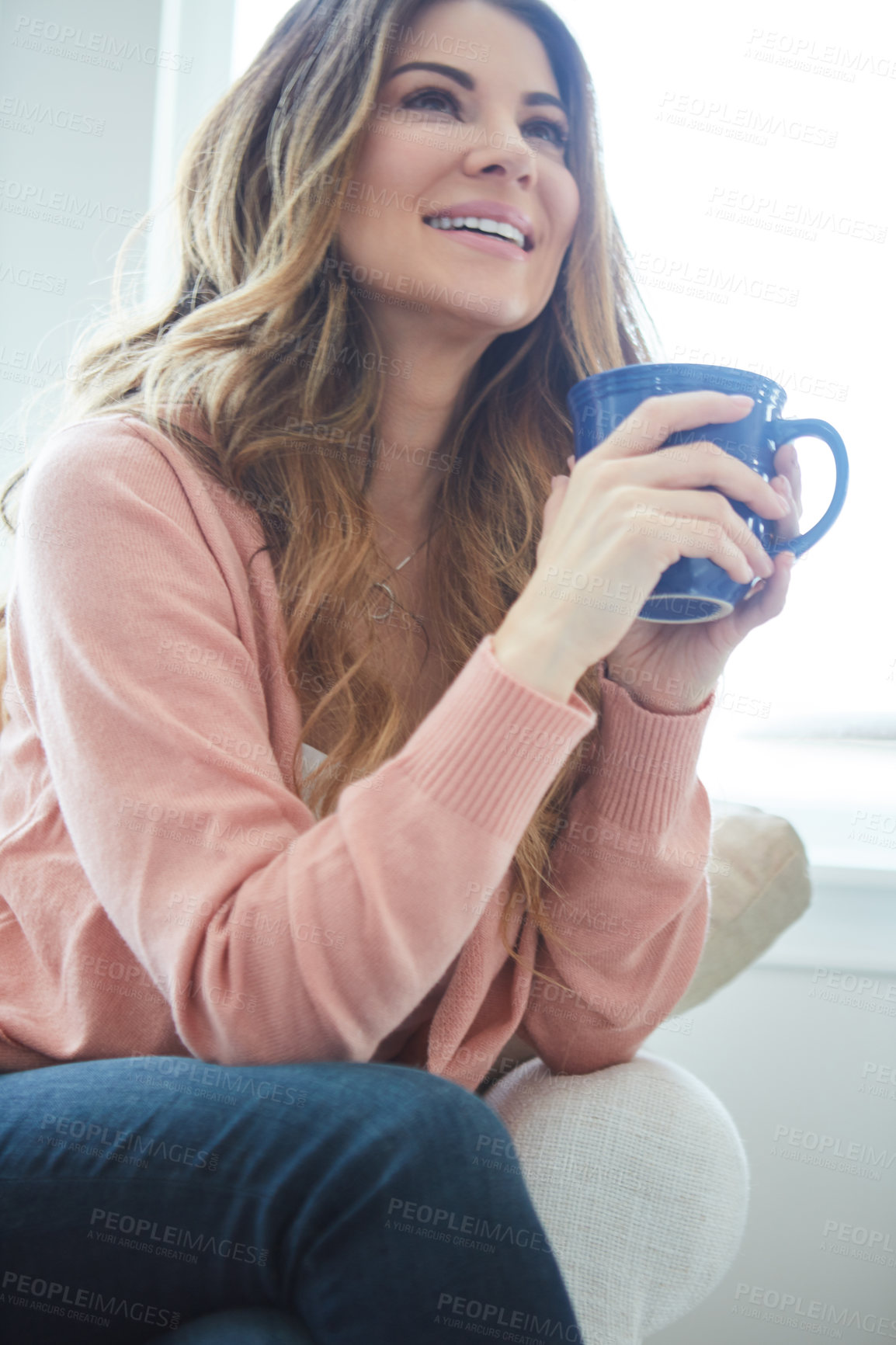 Buy stock photo Shot of a beautiful young woman having coffee while relaxing at home