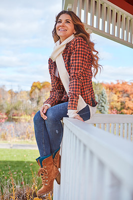 Buy stock photo Full length shot of an attractive young woman sitting on the ledge of a gazebo in the park during autumn