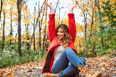 Buy stock photo Cropped shot of an attractive young woman throwing leaves while sitting in the forest during autumn