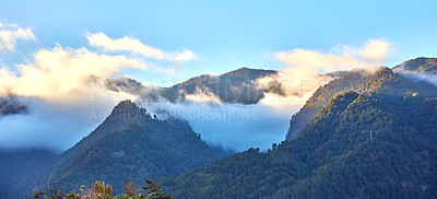 Buy stock photo Beautiful landscape of a mountain with a cloudy blue sky on a summer day. Peaceful and scenic view of peaks with green grass and plants with copy space. Aerial view of uncultivated nature