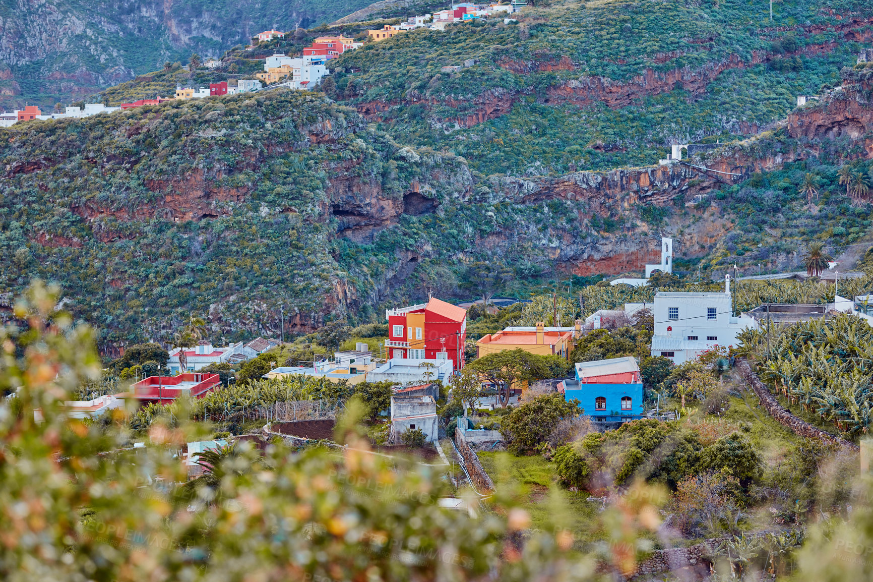 Buy stock photo Architectural colorful buildings of a small hidden town in the mountains. The landscape of a colorful village on the outskirts of nature near a hill. Scenic view of bright buildings near foliage