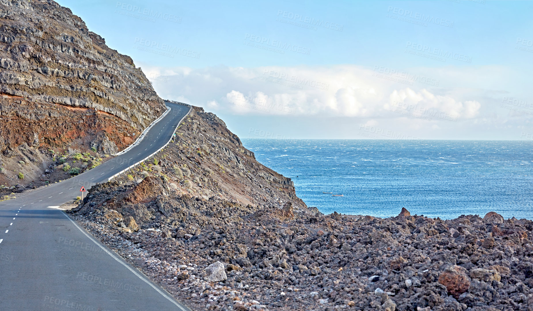 Buy stock photo La Palma island mountain highway for a drive to the cliff top on a winding road by the ocean. Sight seeing by the coast in Spain Curved seaside route with cloudy blue sky and the sea on a background.