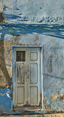 Buy stock photo Exterior of a decaying brick building with peeling paint in Santa Cruz de La Palma. Architectural details of an abandoned rustic property with a damaged, aged door or entrance outside
