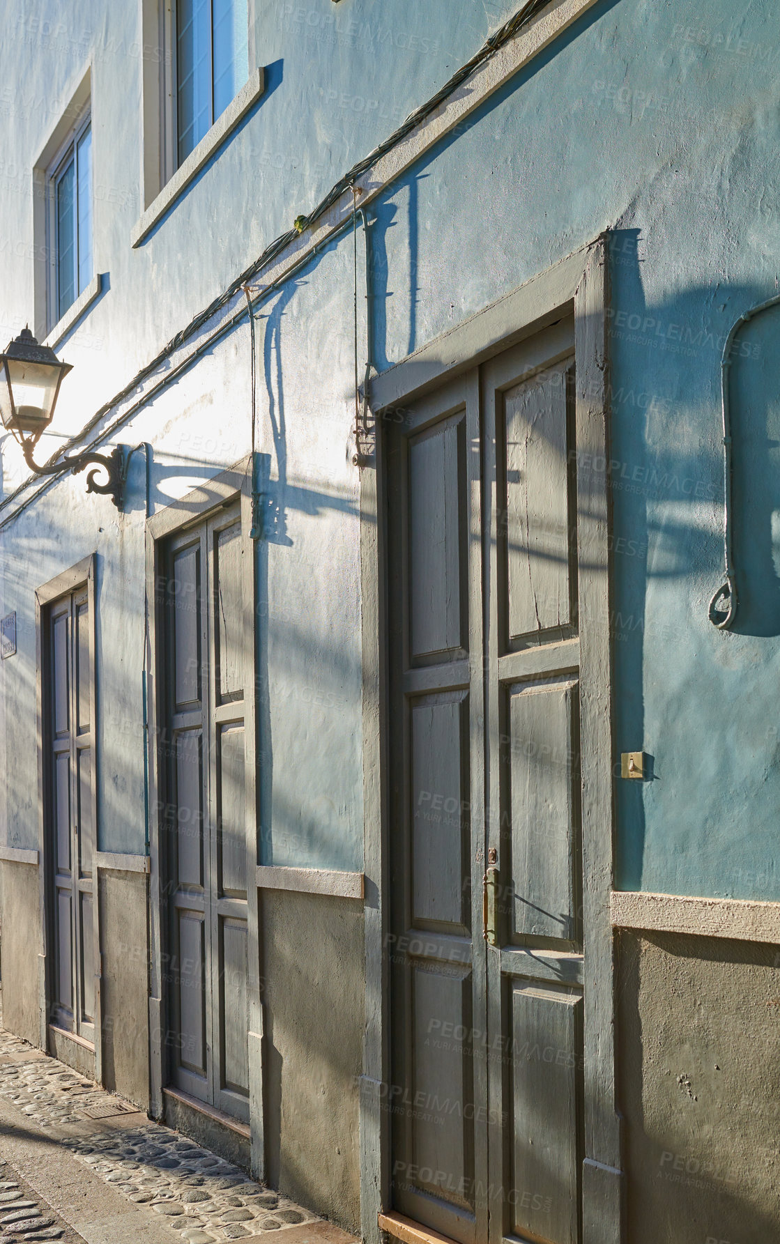 Buy stock photo Classic architecture of vibrant buildings with blue doors in a city. Closeup view of ancient and traditional homes or houses in a small vintage town or village with bright colors and a unique design