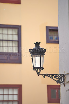 Buy stock photo A street lamp or light on the side of a building in the historic and tourist town of Santa Cruz, La Palma, Canary Islands. Illuminating the roads so traveling tourists can see the sights and views