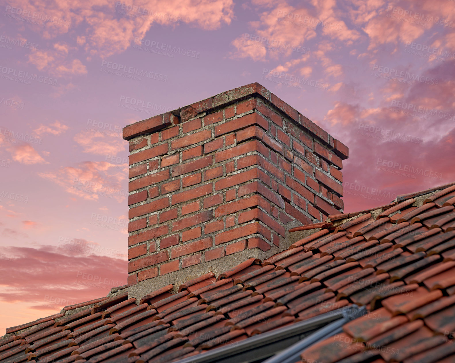 Buy stock photo Closeup of red brick chimney against a colorful sunset sky for combustion gases and home insulation on tiled roof. Architecture design on house building for smoke extraction from fireplace or furnace