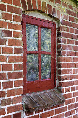Buy stock photo Old dirty window in a brick wall house or home. Ancient casement with red wood frame on a historic building with a clumpy paint texture. Exterior details of a windowsill in a traditional country town