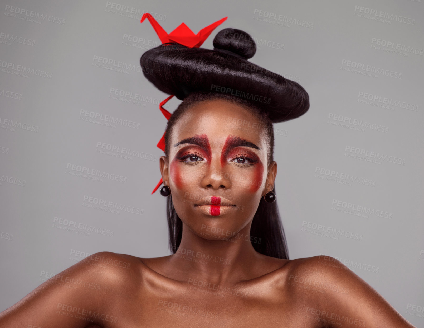 Buy stock photo Portrait, makeup and black woman with origami for art in studio isolated on gray background. Face, creative cosmetics and confident serious model with red paper crane in hair, skincare and beauty