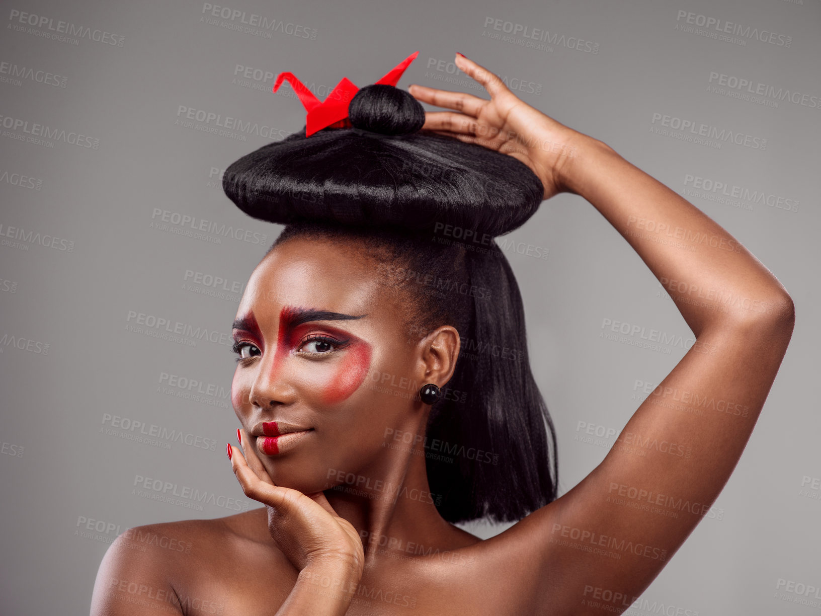 Buy stock photo Portrait, makeup and black woman with origami in hair in studio isolated on gray background. Face, creative cosmetics and confident serious model with red paper crane for beauty, skincare and art
