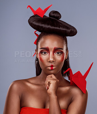 Buy stock photo Portrait, makeup and thinking black woman with origami for beauty in studio isolated on gray background. Face, creative cosmetics and confident model with paper crane in hair, skincare and art idea