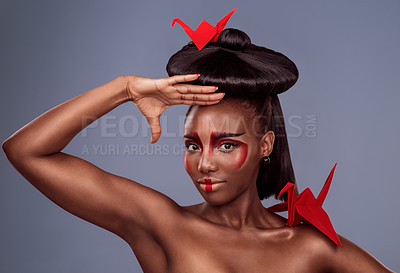 Buy stock photo Portrait, beauty and black woman with origami for art, makeup or skin in studio isolated on gray background. Face, creative cosmetics and confident model with oriental paper crane in hair for culture