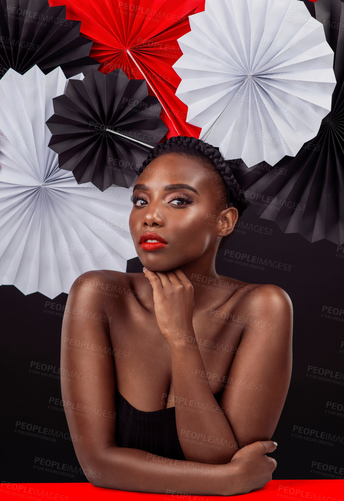 Buy stock photo Creative, portrait and black woman with origami fans in studio, beauty and dark background. Face, makeup and cosmetics of female model with pride, traditional care and paper art for culture hat