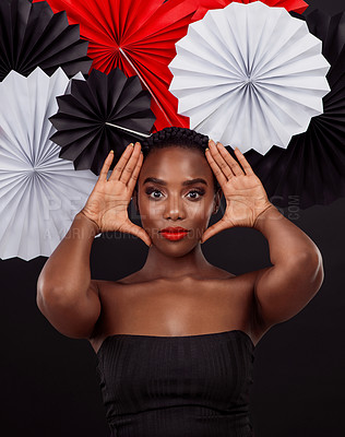 Buy stock photo Black woman, origami fans and hand with makeup for skin glow or shine with creative artwork isolated in dark background. African female person or model and traditional oriental art with fashion