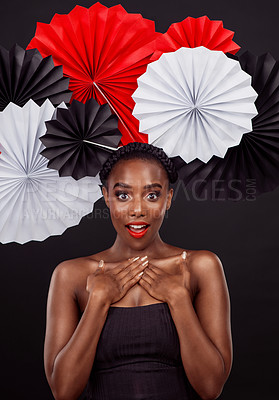 Buy stock photo Portrait, surprise and black woman with origami fans, makeup and beauty against a black background. Face, female person and model with paper art, creative and announcement with fashion and creativity