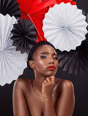 Buy stock photo Face, makeup and black woman with origami fans in studio isolated on a dark background. Portrait, beauty cosmetics and skincare of serious female model with traditional Japanese paper hat for art.