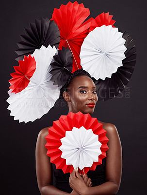 Buy stock photo Portrait, black woman and paper for fans in studio with makeup for beauty or cosmetics for glamour with elegance in dark background. Female person, skincare and treatment or glow with origami art