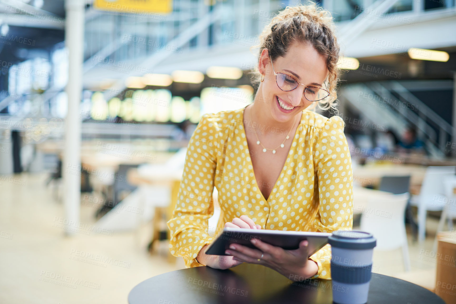 Buy stock photo Shot of a young businesswoman using a digital tablet during a coffee break in a modern office