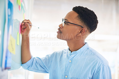 Buy stock photo Shot of a young businessman having a brainstorming session in a modern office