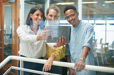 Buy stock photo Shot of a group of young businesspeople taking a selfie together in a modern office