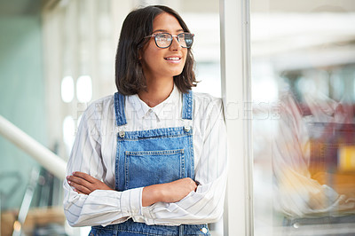 Buy stock photo Shot of a confident young businesswoman looking thoughtful in a modern office