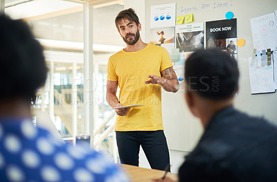 Buy stock photo Shot of a young businessman using a digital tablet during a presentation in a modern office