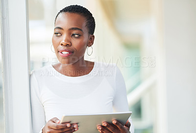 Buy stock photo Shot of a young businesswoman using a digital tablet in a modern office