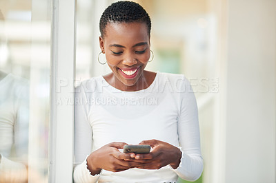 Buy stock photo Shot of a young businesswoman using a smartphone in a modern office