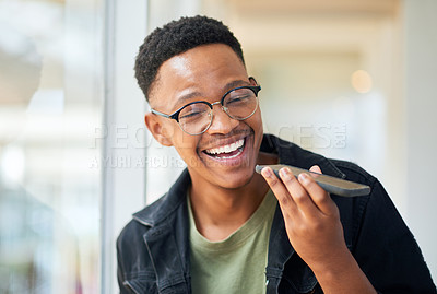 Buy stock photo Shot of a happy young businessman using a smartphone in a modern office