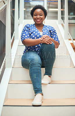 Buy stock photo Portrait of a confident young businesswoman sitting on the steps of a modern office