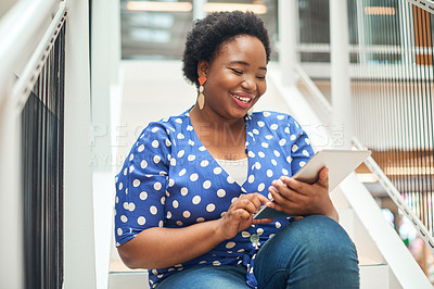 Buy stock photo Shot of a young businesswoman using a digital tablet on the stairs of a modern office