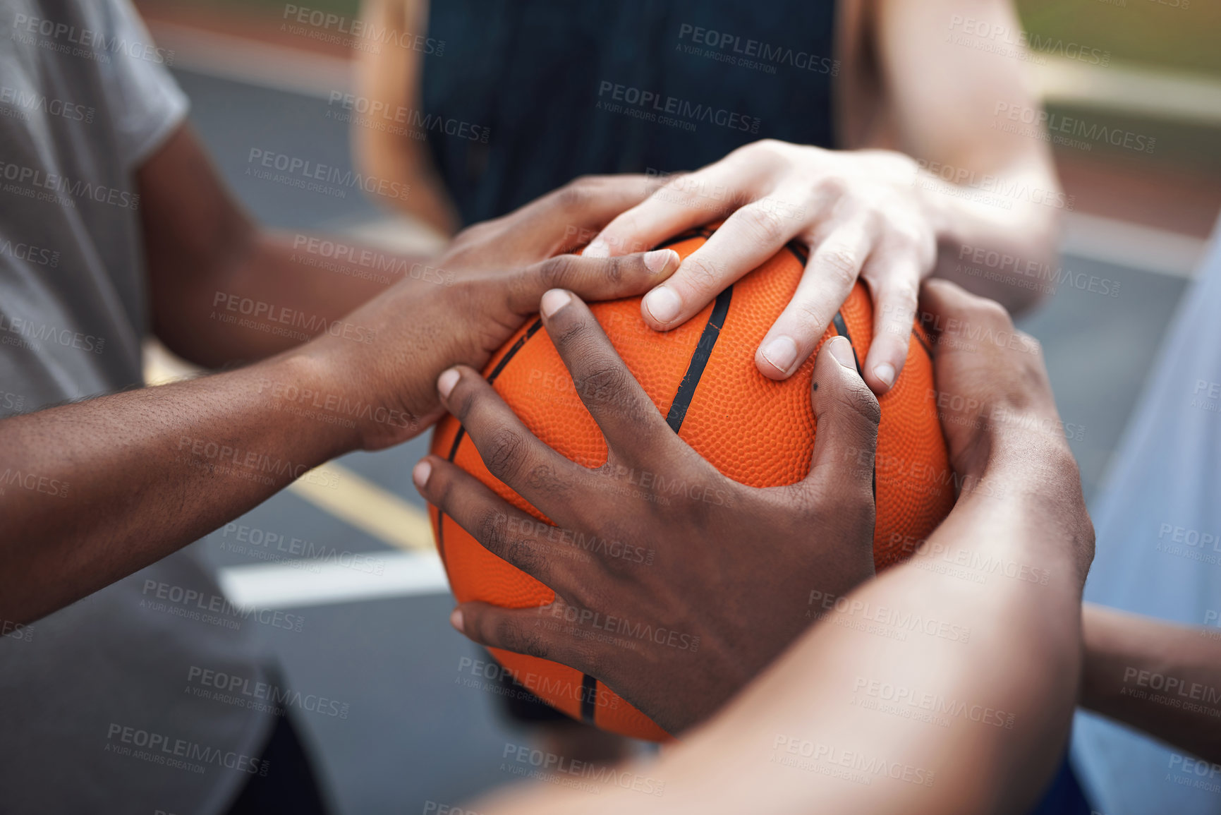 Buy stock photo Closeup shot of a group of sporty young men huddled around a basketball on a sports court