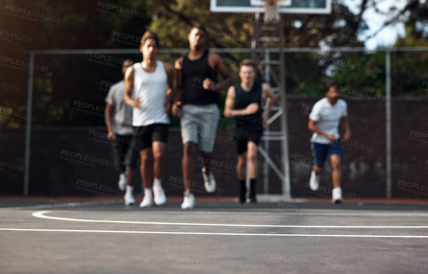 Buy stock photo Defocused shot of a group of sporty young men running on a sports court