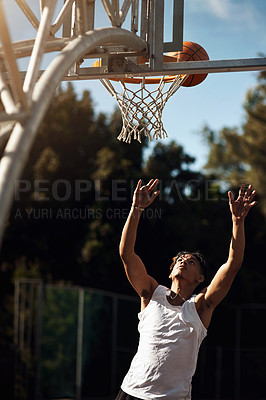 Buy stock photo Shot of a sporty young man playing basketball on a sports court