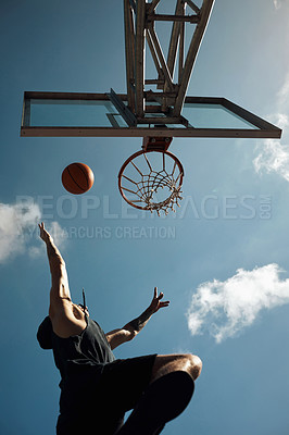 Buy stock photo Shot of a sporty young man playing basketball on a sports court