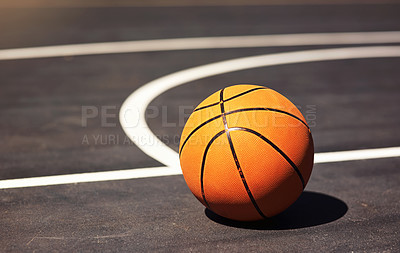 Buy stock photo Still life shot of a basketball on the ground in a sports court