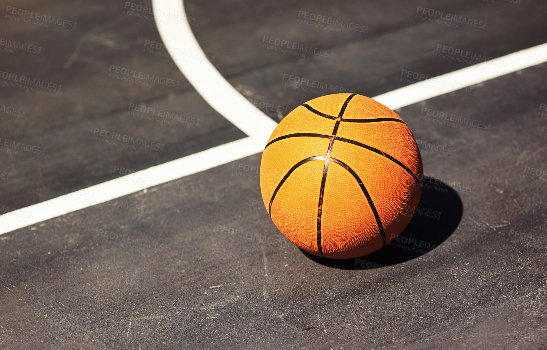 Buy stock photo Still life shot of a basketball on the ground in a sports court