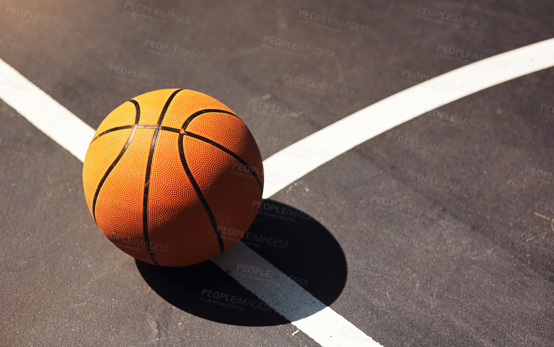 Buy stock photo Still life shot of a basketball on the ground in a sports court