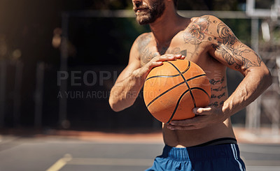 Buy stock photo Closeup shot of a sporty man holding a basketball on a sports court