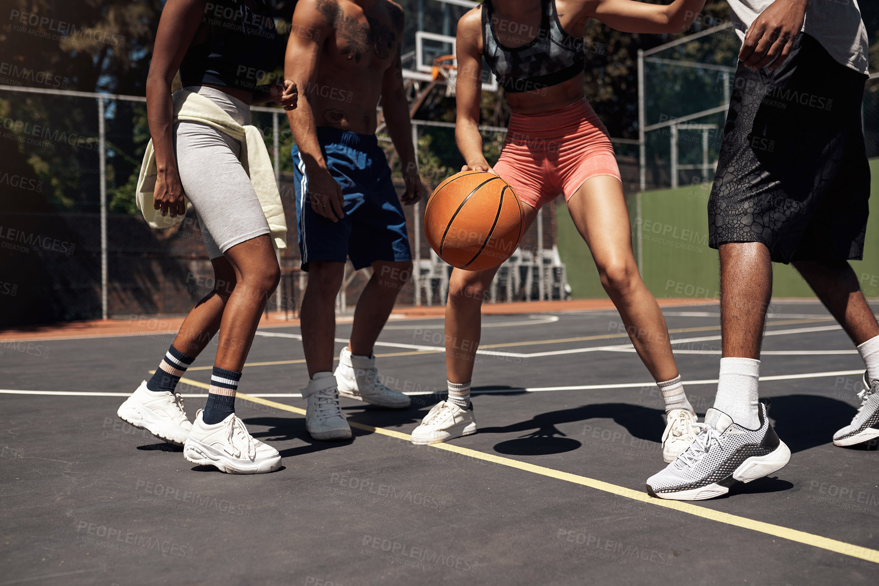 Buy stock photo Closeup shot of a group of sporty young people playing basketball on a sports court