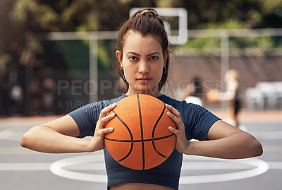 Buy stock photo Portrait of a sporty young woman holding a basketball on a sports court