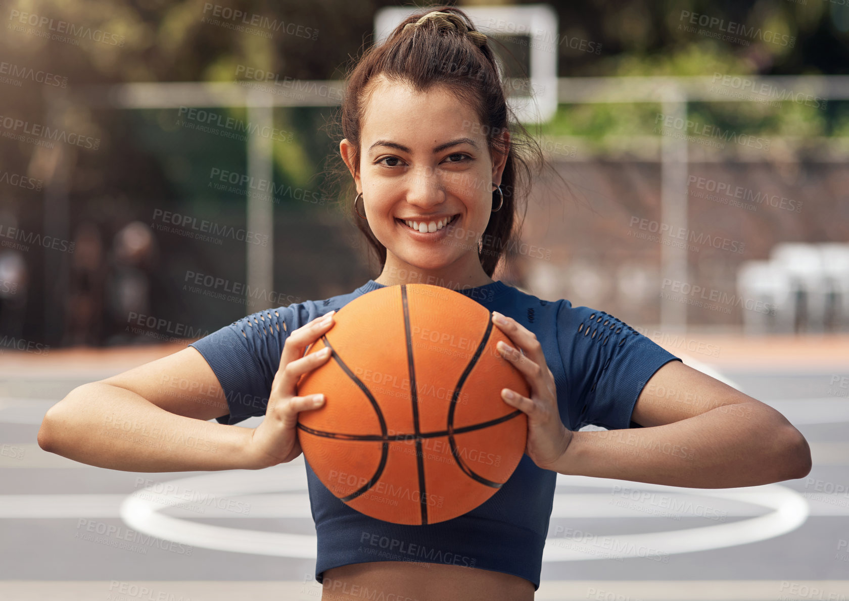 Buy stock photo Portrait of a sporty young woman holding a basketball on a sports court