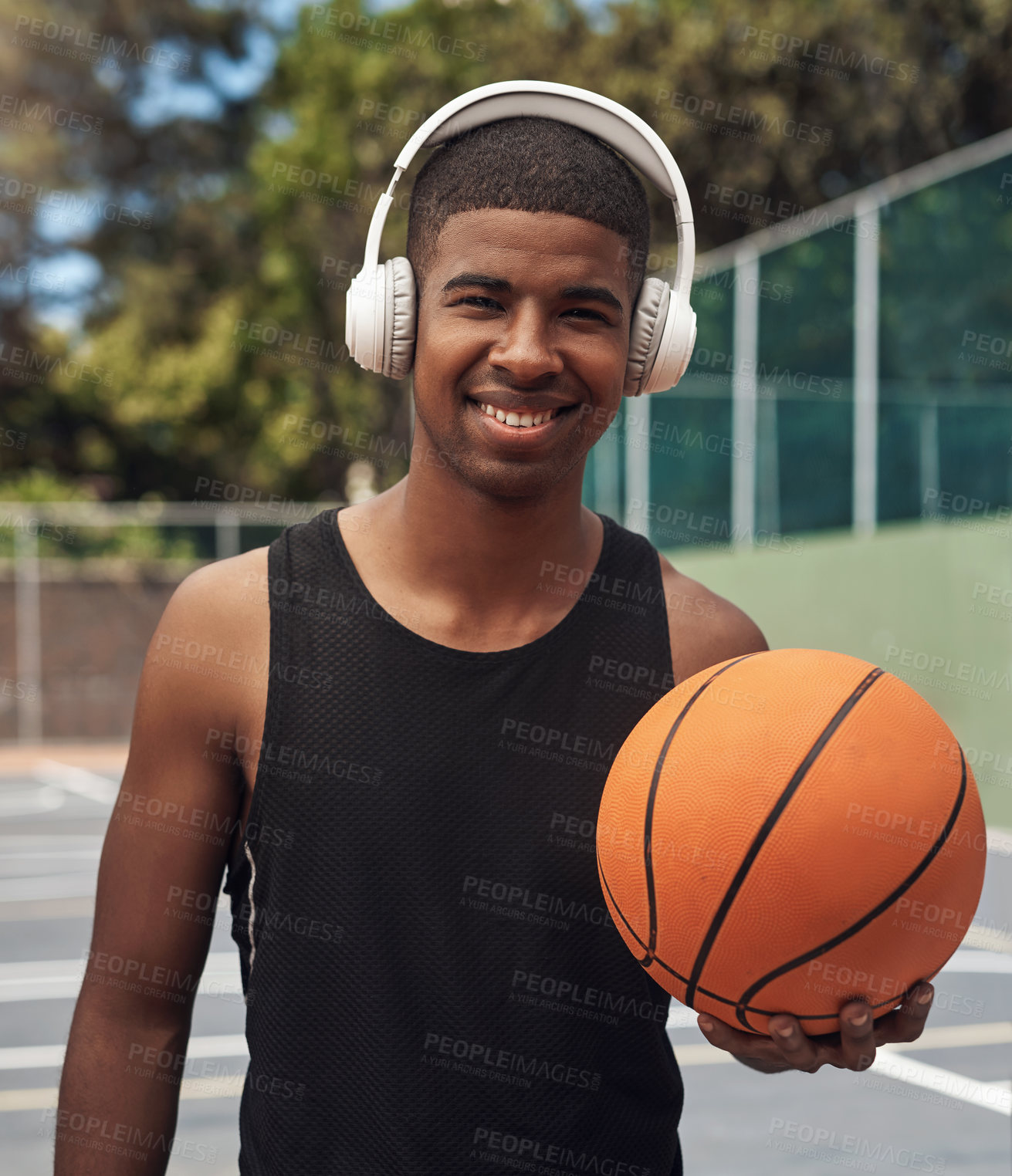 Buy stock photo Portrait of a sporty young man listening to music while playing basketball on a sports court