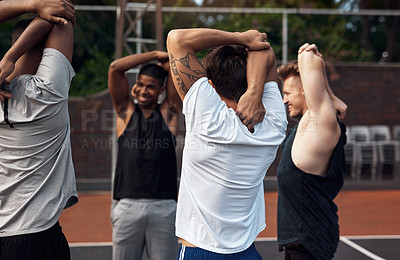 Buy stock photo Shot of a group of sporty young men stretching their arms on a sports court