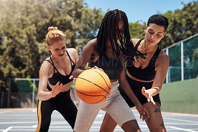 Buy stock photo Shot of a group of sporty young women playing basketball on a sports court