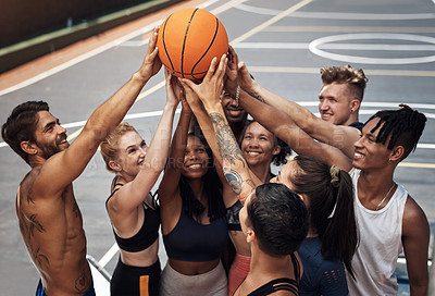 Buy stock photo Shot of a group of sporty young people standing together in a huddle around a basketball on a sports court