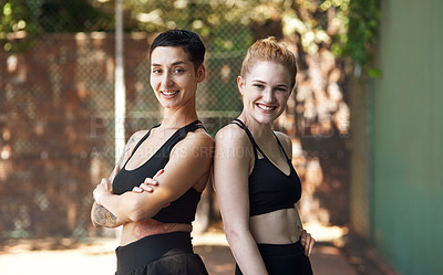 Buy stock photo Cropped portrait of two attractive young female athletes standing back to back on the basketball court