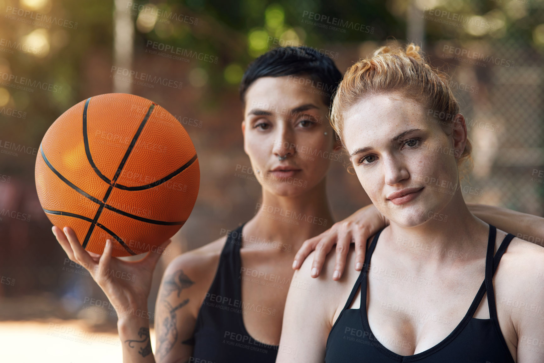 Buy stock photo Cropped portrait of two attractive young female athletes standing together on the basketball court